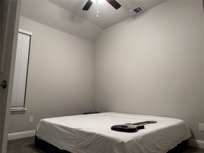 Carpeted bedroom featuring lofted ceiling and ceiling fan | Image 10