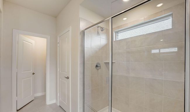 Full bathroom featuring a shower stall, light tile patterned flooring, and a closet | Image 10