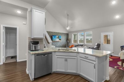 with sink, dark hardwood / wood-style floors, tasteful backsplash, and stainless steel dishwasher | Image 2