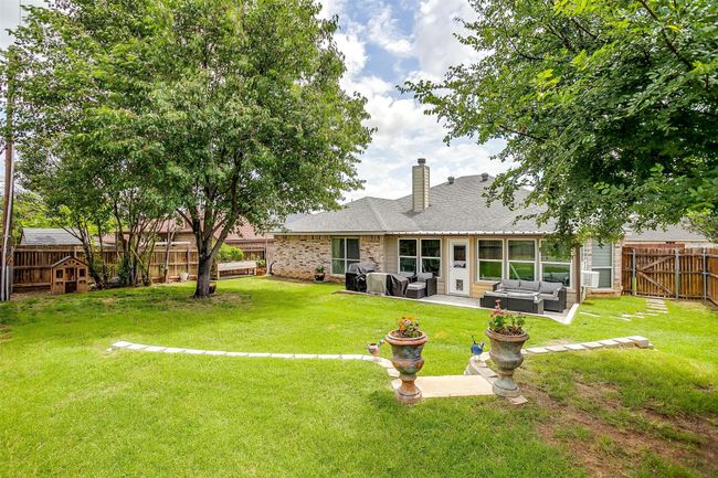 Back of house featuring an outdoor hangout area, a fenced backyard, a patio area, and a shingled roof | Image 36