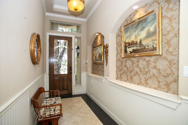 Foyer entrance featuring wainscoting, crown molding, a decorative wall, and tile patterned flooring | Image 30