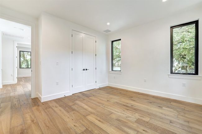 Unfurnished bedroom with multiple windows, light wood-type flooring, baseboards, and recessed lighting | Image 29