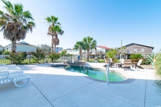View of pool with a patio area, fence, a residential view, and a pool with connected hot tub | Image 11