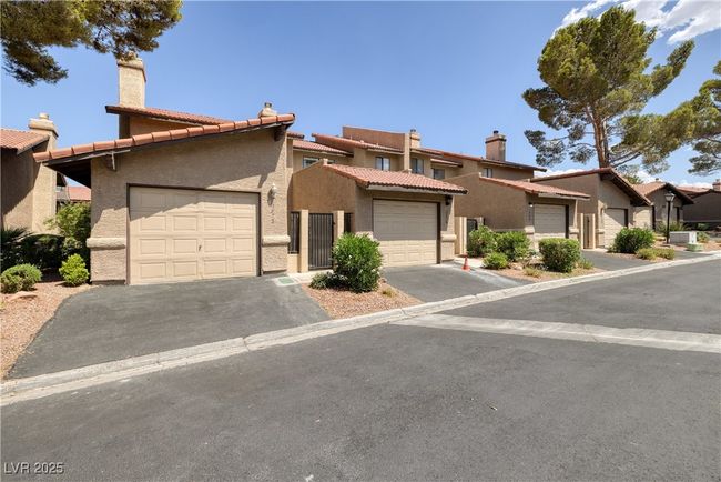 Townhome / multi-family property with stucco siding, a garage, and a tile roof | Image 28