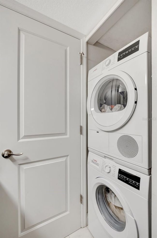 Washer/dryer is neatly hidden behind a door. | Image 20