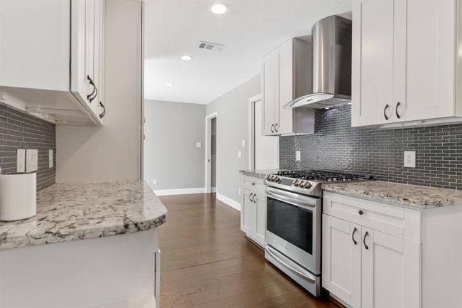The kitchen has ample storage space with cabinetry above and below with matching hardware. This view looks into the breakfast room as well. | Image 13