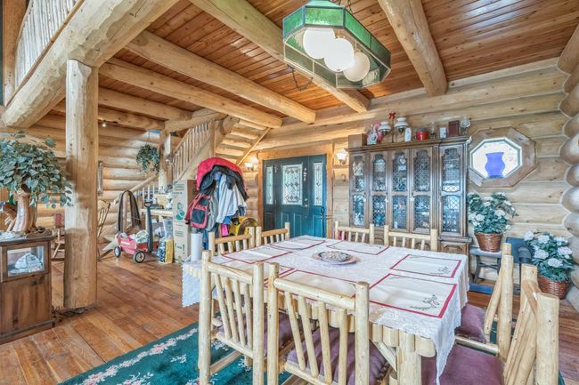 Dining room with log walls, wood ceiling with exposed beams, and hardwood / wood-style floors | Image 22