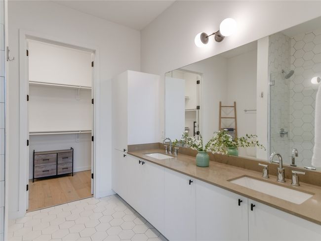 Full bath featuring a spacious closet, a stall shower, double vanity, and a sink | Image 16