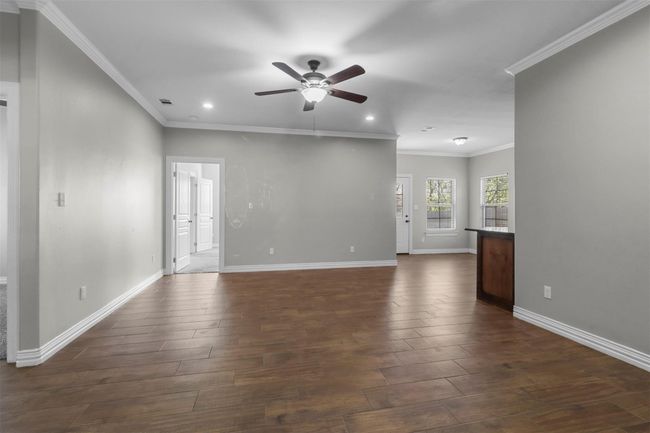 Unfurnished room featuring a ceiling fan, recessed lighting, dark wood finished floors, and crown molding | Image 5