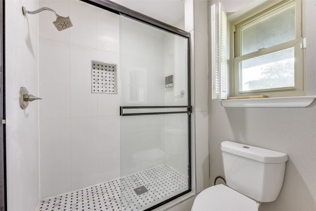 Full bathroom featuring a shower stall and toilet | Image 21