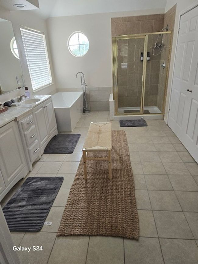 Bathroom with a soaking tub, vanity, tile patterned flooring, and a stall shower | Image 17