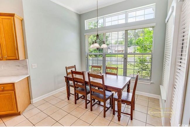 Dining room featuring a chandelier, plenty of natural light, light tile patterned floors, and crown molding | Image 16