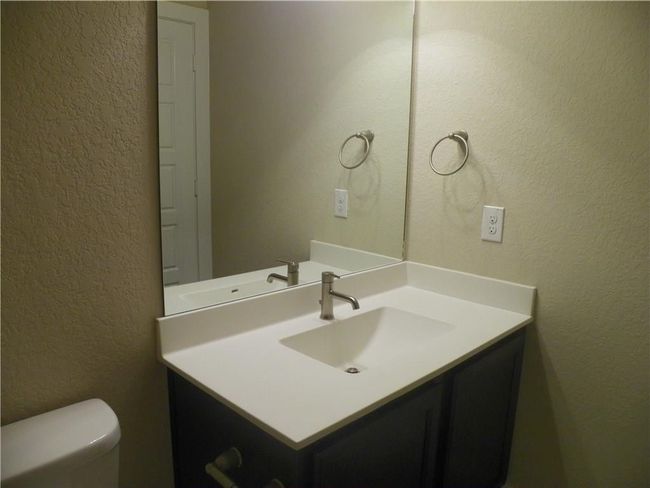 Bathroom featuring a textured wall, vanity, and toilet | Image 10