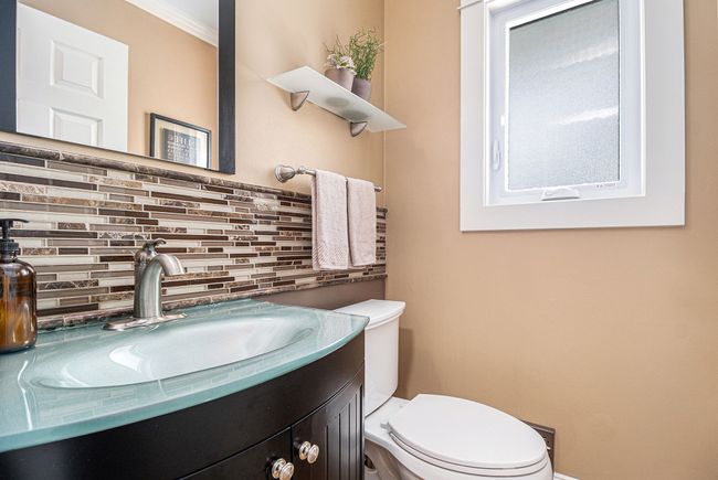 Refreshed half bath tucked by garage access. | Image 11
