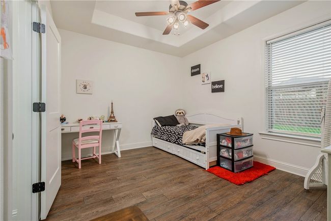 Bedroom with a raised ceiling, wood finished floors, baseboards, and multiple windows | Image 19