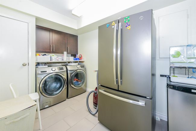 Laundry room featuring washer and clothes dryer and light tile patterned flooring | Image 31