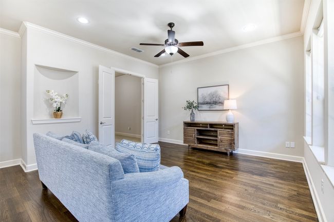 Living room with ceiling fan and crown molding. | Image 6