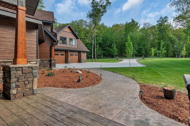 Beautifully landscaped front yard featuring a stamped concrete walkway and a durable concrete driveway, offering great curb appeal and a welcoming entrance. | Image 6