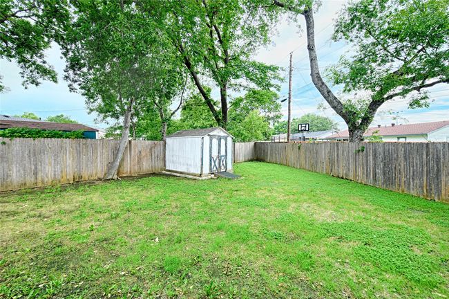Fenced backyard featuring large shed | Image 20