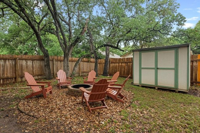 Fenced backyard with an outdoor fire pit and a storage unit | Image 30