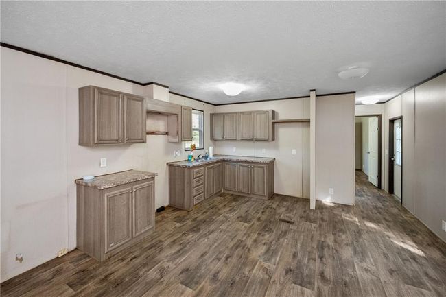 Kitchen with dark wood finished floors and a textured ceiling | Image 17