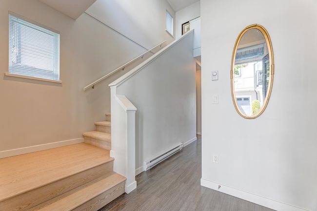 Stairway featuring baseboard heating and wood finished floors | Image 4