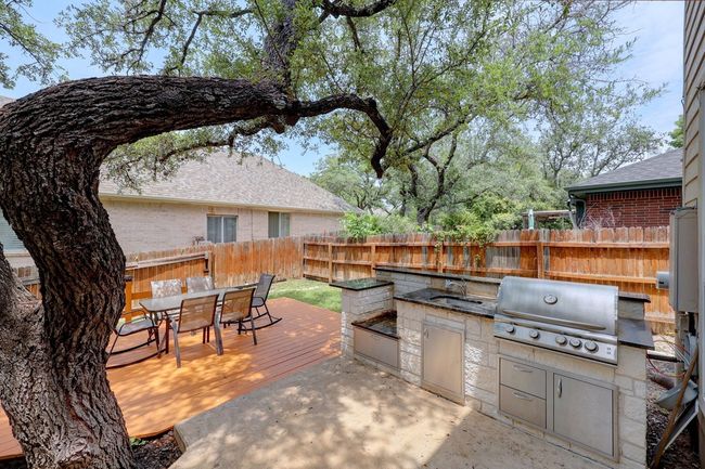 View of patio with a fenced backyard, an outdoor kitchen, area for grilling, a wooden deck, and outdoor dining area | Image 31
