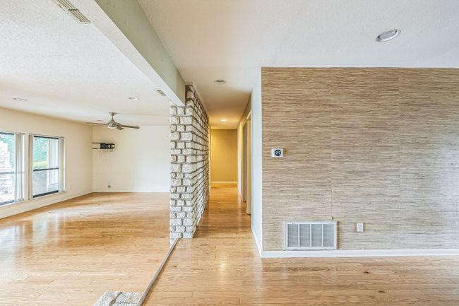 Hall with visible vents, wood finished floors, and baseboards | Image 8
