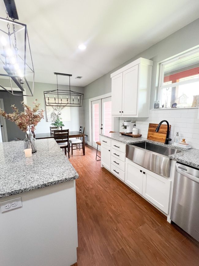Kitchen with dishwasher, sink, hanging light fixtures, dark hardwood / wood-style floors, and white cabinets | Image 4