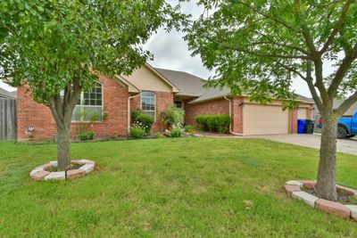 Ranch-style home with a garage and a front lawn | Image 2