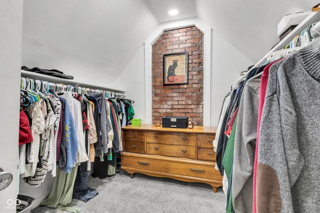 Walk in closet featuring carpet and vaulted ceiling. | Image 29