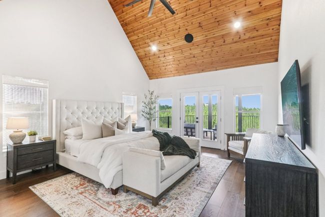 Bedroom featuring high vaulted ceiling, access to exterior, wooden ceiling, and dark wood finished floors | Image 4