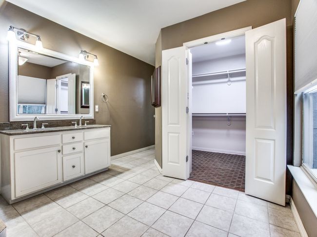 Bathroom with tile patterned flooring, double vanity, a walk in closet, and a sink | Image 19