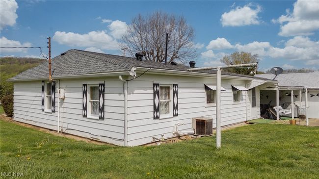 View of side of home with a yard, central AC, and roof with shingles | Image 36