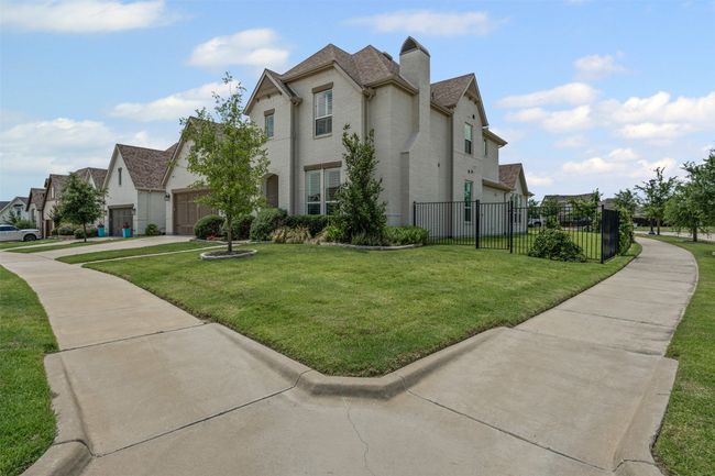 View of home's exterior featuring a garage, brick siding, a residential view, driveway, and a chimney | Image 36
