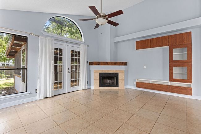 . Vaulted ceilings stretch high overhead, while wide windows and French doors fill the space with soft, natural light. | Image 15