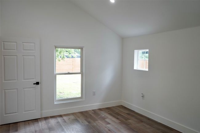 Spare room featuring healthy amount of natural light, vaulted ceiling, and wood finished floors | Image 20