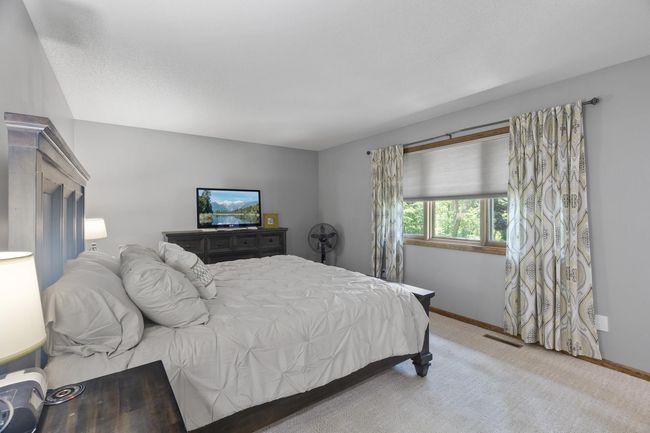 Upper-level owner’s suite with a picturesque window overlooking the private backyard, a ¾ en suite bath, and a spacious walk-in closet—your personal retreat. | Image 20