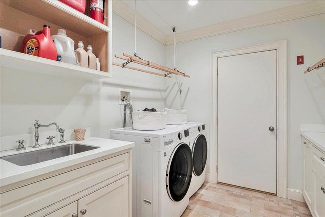 Laundry area with plenty of cabinet space, ornamental molding, recessed lighting, a sink, and LG washing machine and dryer. | Image 27