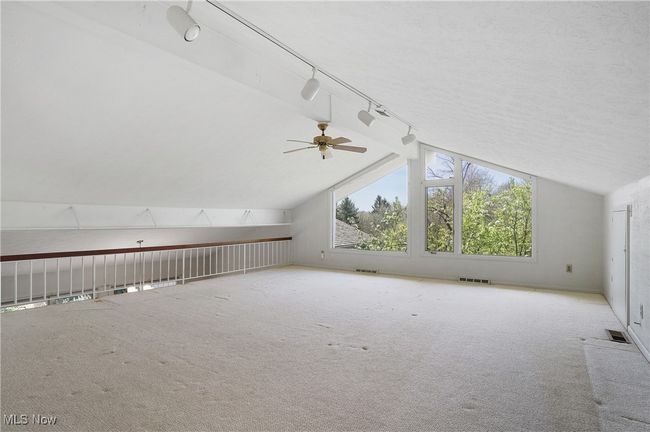 Additional living space with ceiling fan, vaulted ceiling, visible vents, and carpet | Image 24
