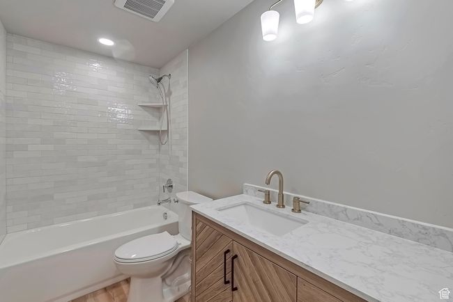 Bathroom featuring toilet, vanity, shower / washtub combination, and wood finished floors | Image 23