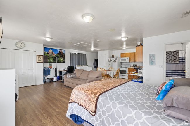 Bedroom featuring wood finished floors and white refrigerator with ice dispenser | Image 39