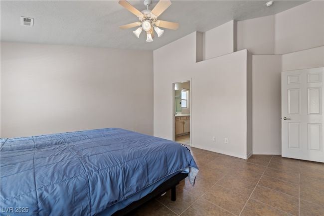 Bedroom with tile patterned floors, ensuite bath, and a ceiling fan | Image 24