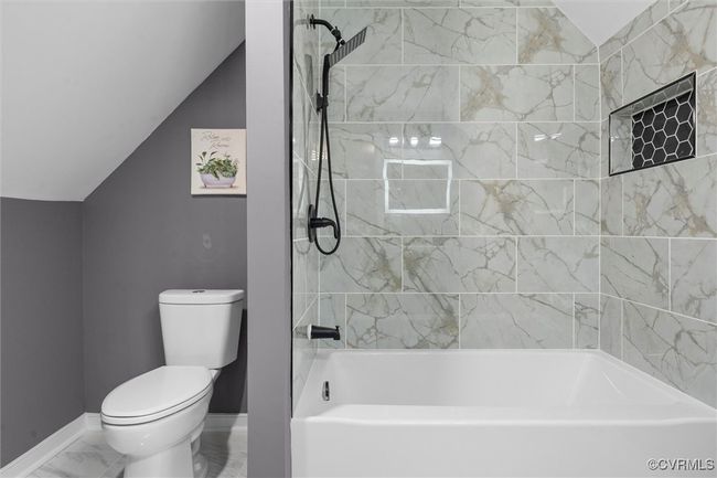 Full Bathroom featuring vaulted ceiling, shower / bath combination, and marble finish floors | Image 30