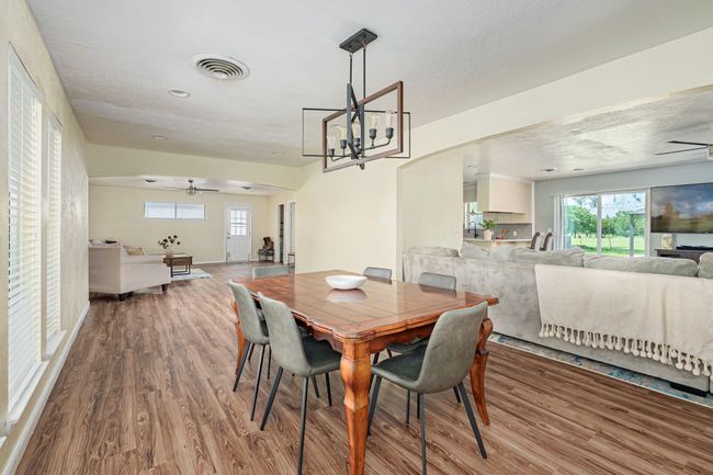 Dining area featuring ceiling fan, wood finished floors, and healthy amount of natural light | Image 20