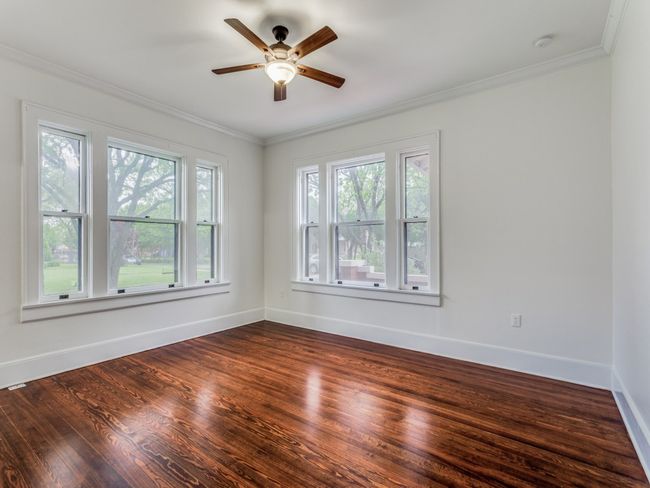 Primary bedroom, natural light, hardwood floors and ceiling fan | Image 13