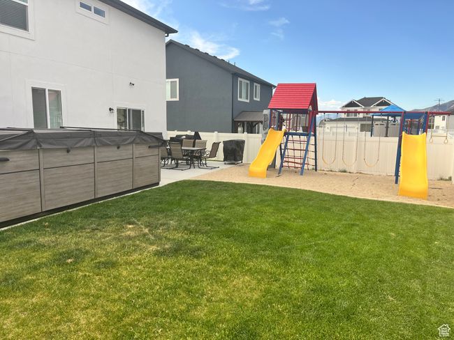 View of yard featuring a playground and a patio area | Image 31