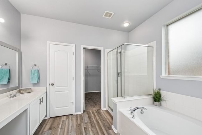 Bathroom featuring visible vents, a bath, vanity, wood finished floors, and a stall shower | Image 25