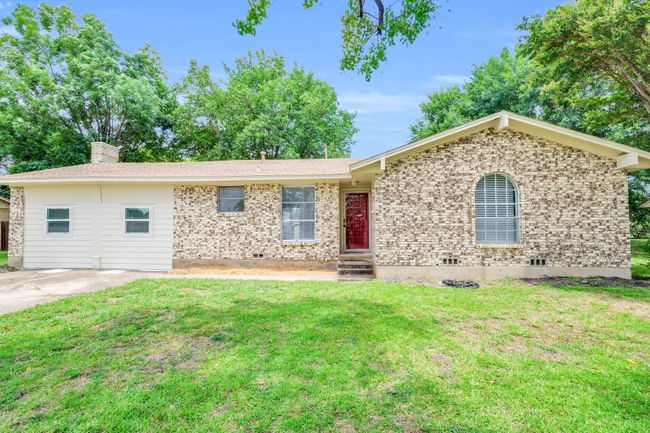 Ranch-style home with brick siding, a front yard, and a chimney | Image 5