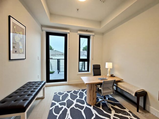 Office space with baseboards, a tray ceiling, and wood finished floors | Image 10